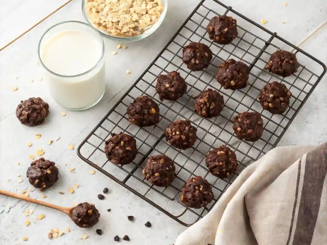 finished-no-bake-oat-clusters No-bake chocolate oat clusters cooling on wire rack beside a glass of milk